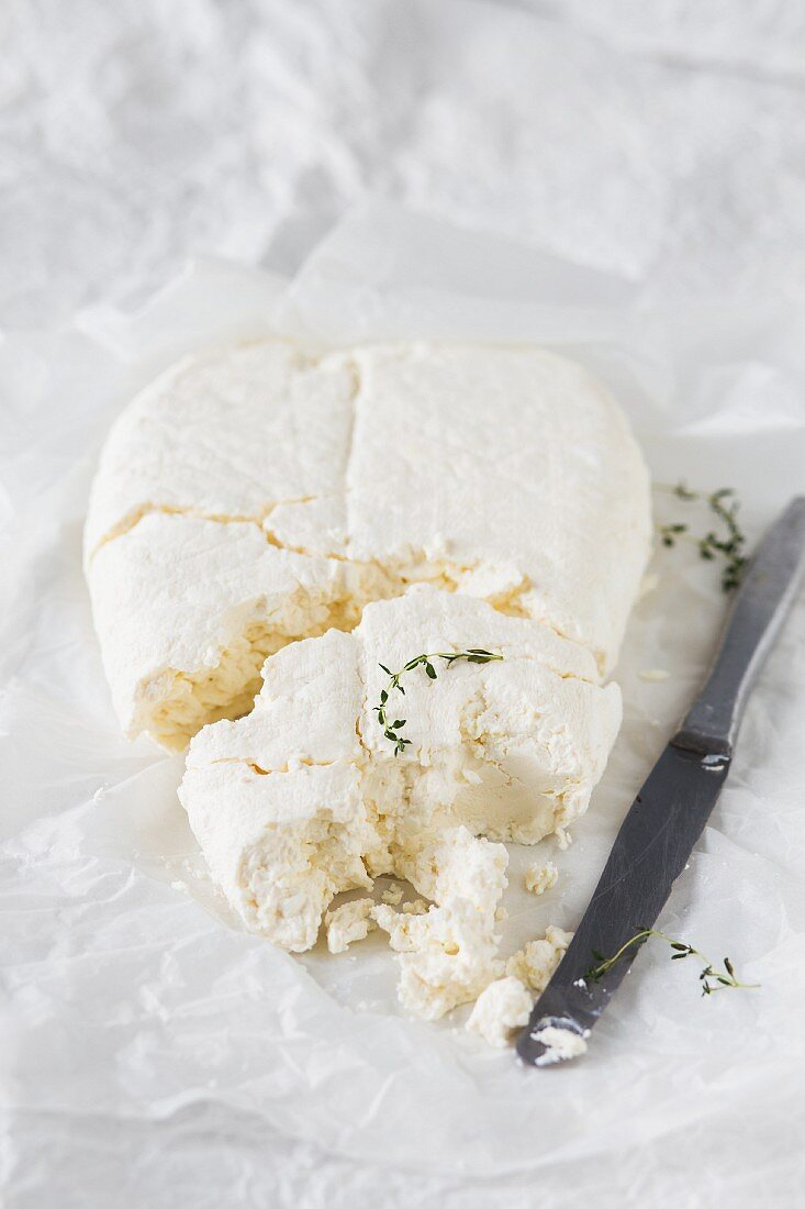 White farmers cheese with thyme and a knife