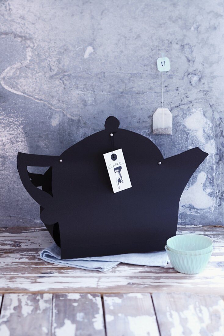 A teapot cut out of black construction paper as gift wrap for a cake