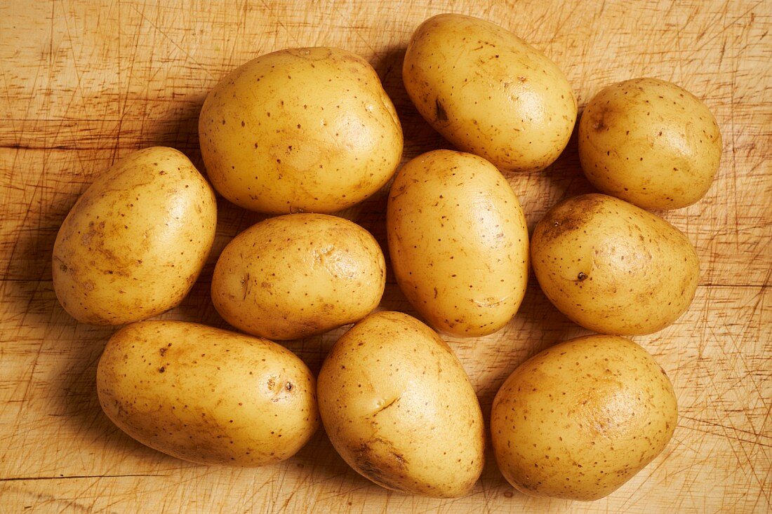 Small uncooked potatoes on a wooden surface