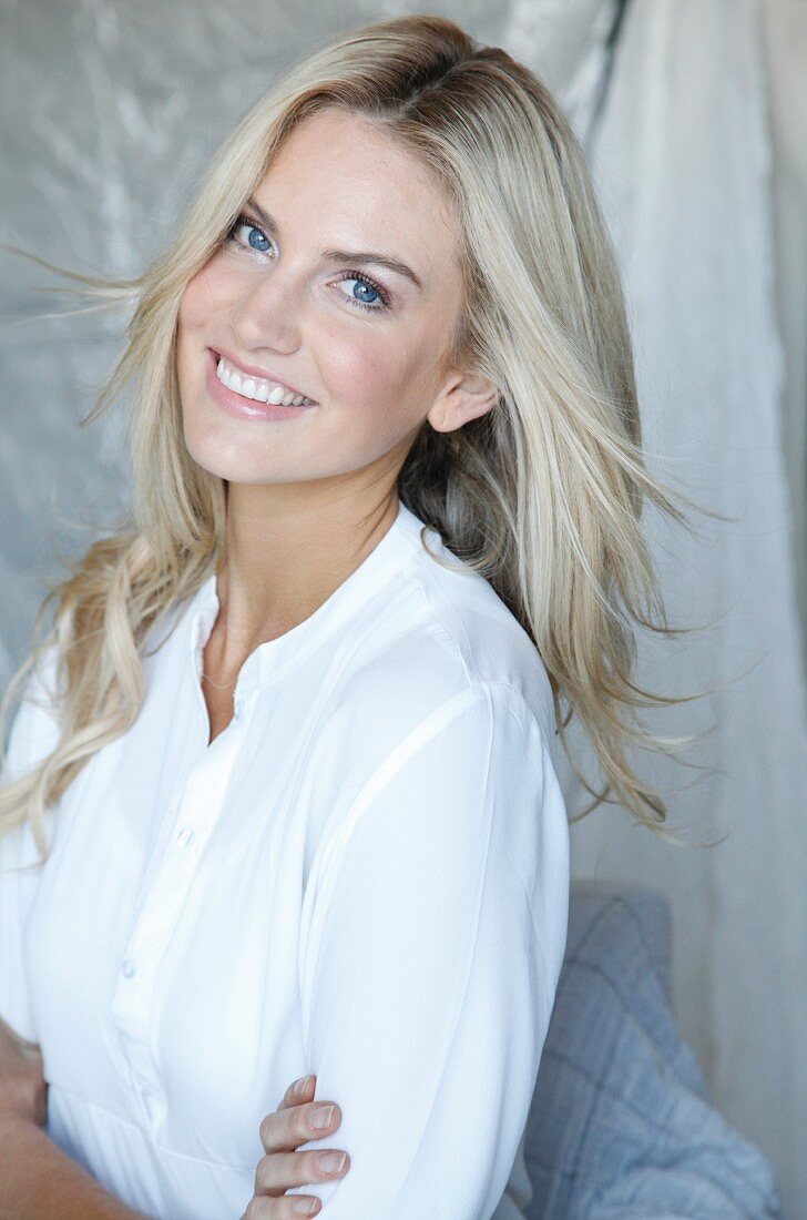 Woman with long blonde hair wearing white blouse