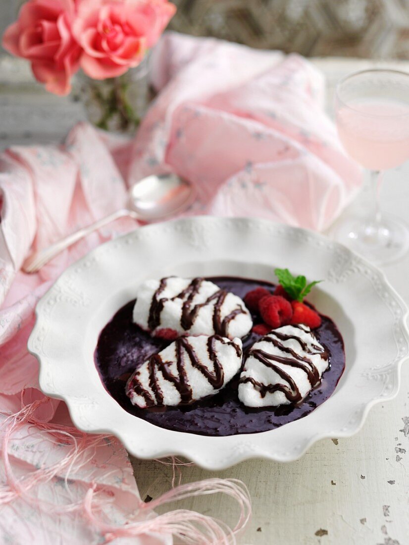 Egg white dumplings in a berry soup with chocolate sauce