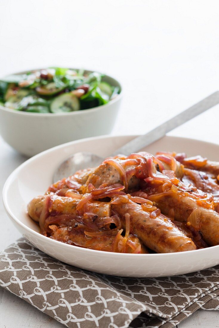 Pork sausages with onions and a spinach and bean salad