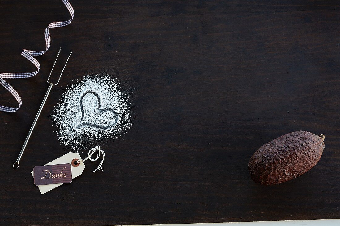 A heart in icing sugar and a cocoa fruit