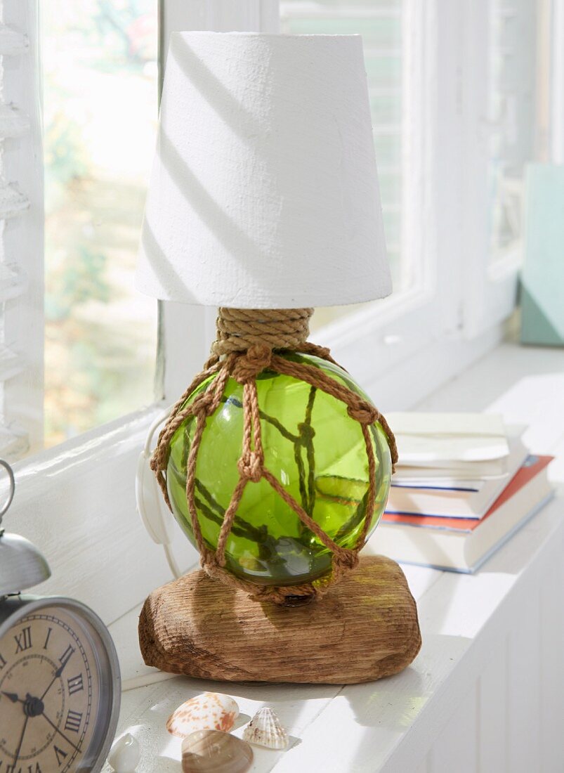 A handmade table lamp with a stand made from a fishing net and driftwood