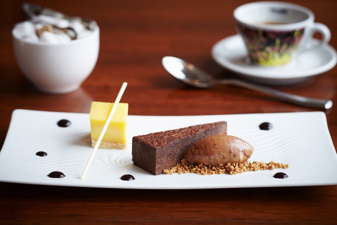 Dreierlei Desserts: Schokoladentorte, Zitronentarte und Eisnocke auf Biskuitboden