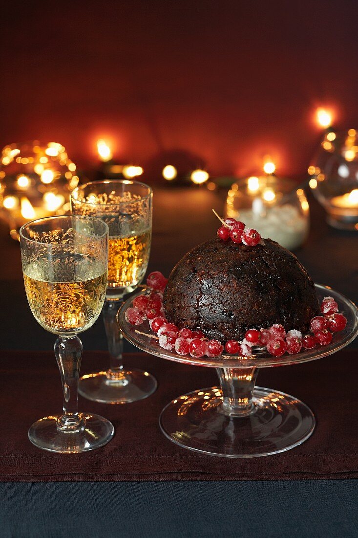 Christmas pudding with redcurrants and two glasses of white wine