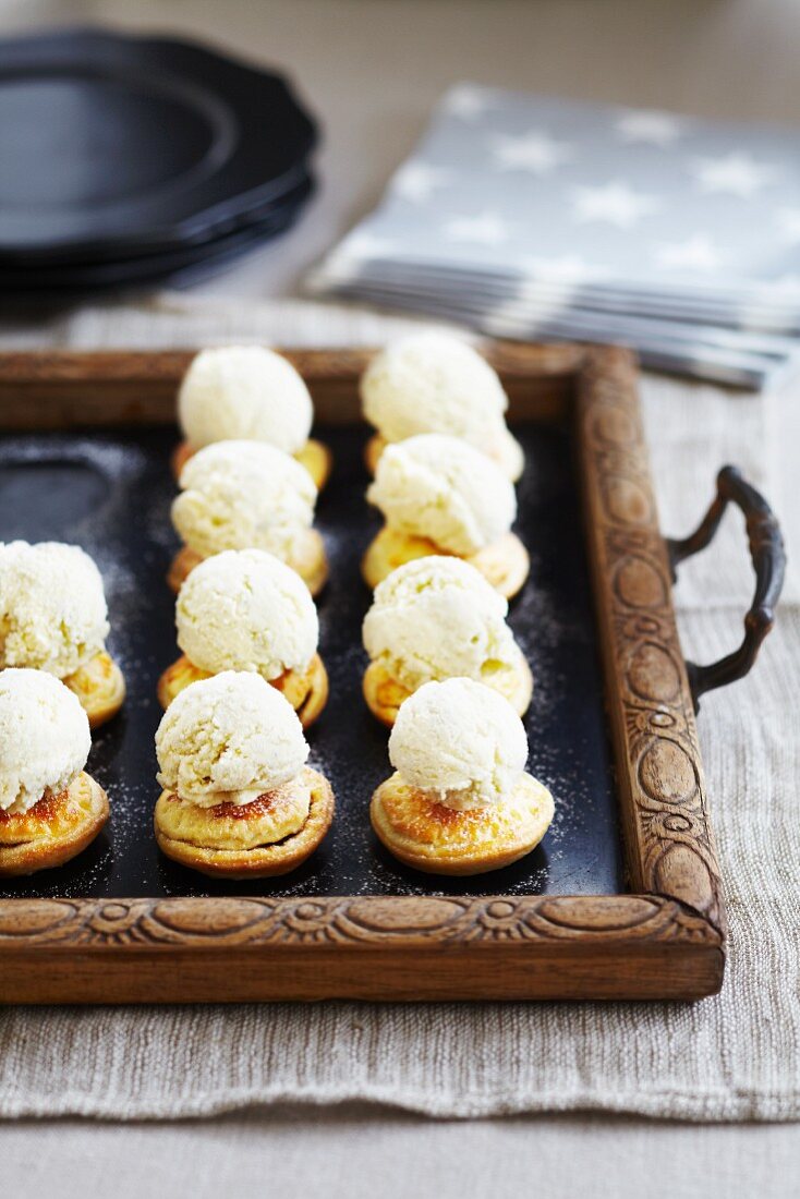 Mini mince pies with ice cream on a tray