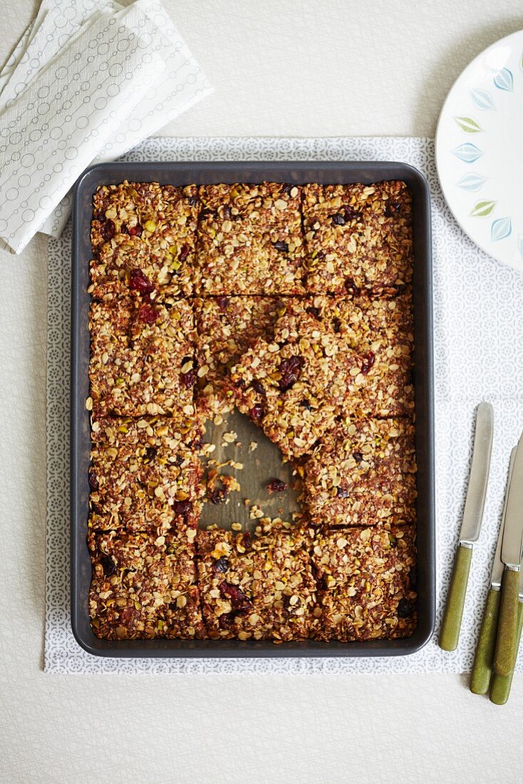 Flapjacks with cranberries and pistachios on a baking tray