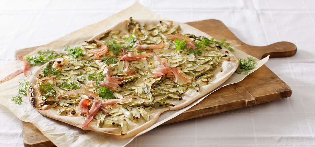 Tarte flambée with green asparagus and raw ham