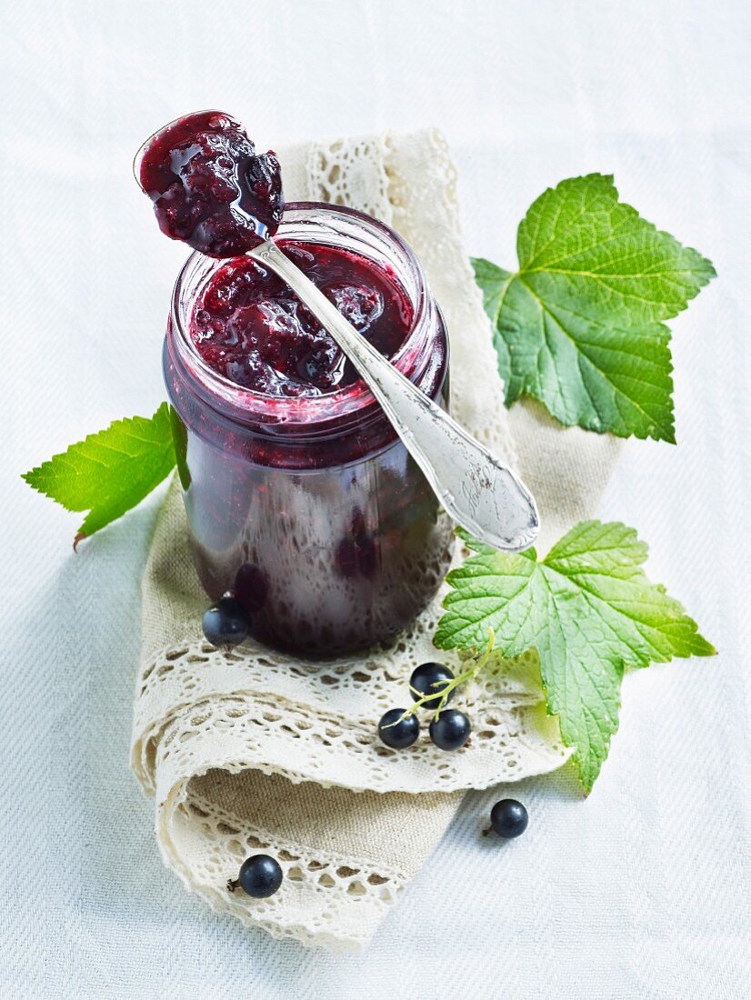 Blackcurrant jam in a jar and on a spoon