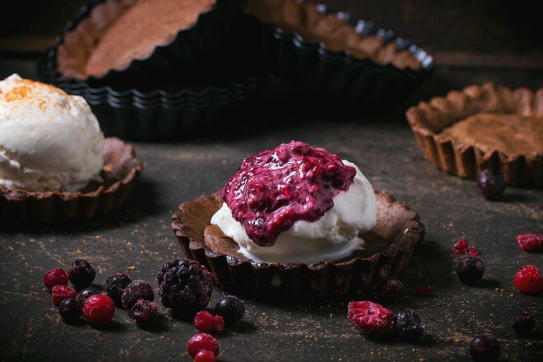 Hausgemachtes Eis mit gefrorenen Beeren in Schokoladentorteletts