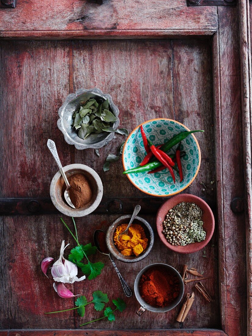 Various spices and herbs on a wooden tray