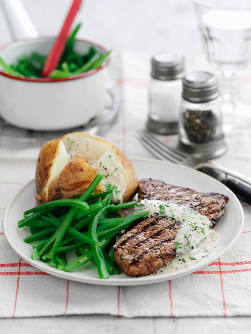 Beef steak with dill sauce, baked potatoes and green beans
