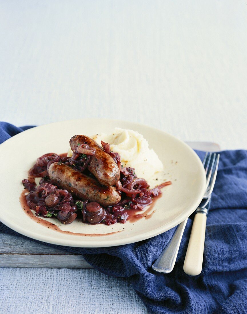 Sausages with an onion-mushroom-red wine sauce and mashed potatoes