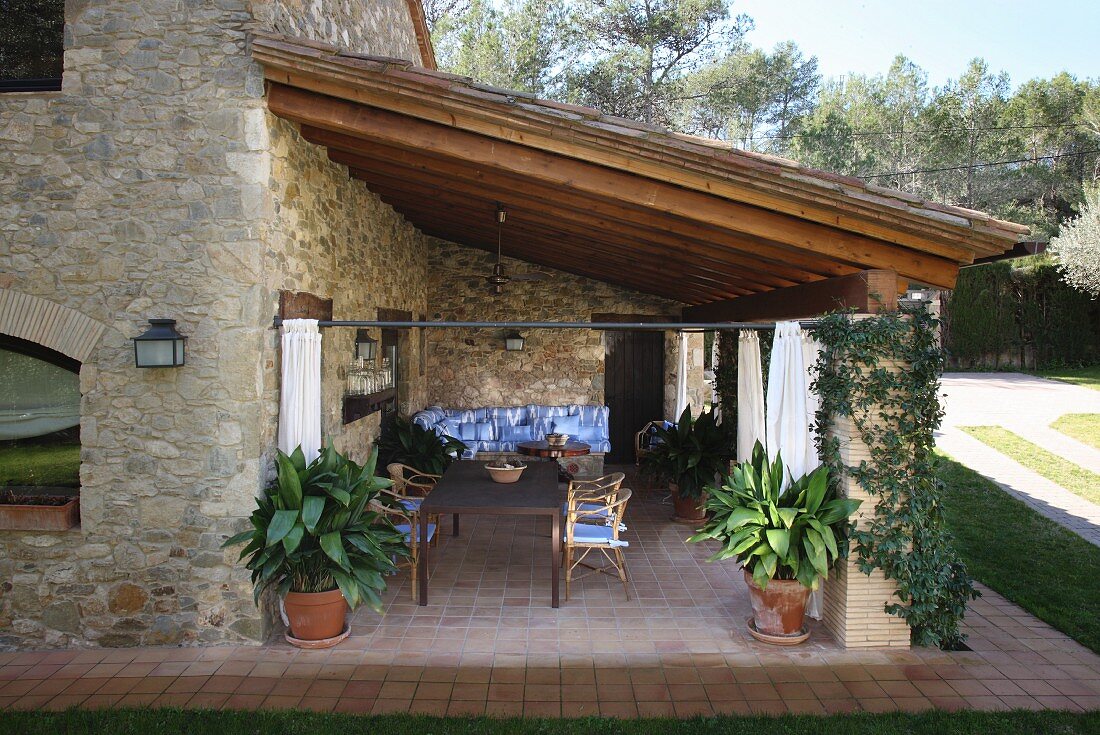 Essplatz auf überdachter Terrasse eines spanischen Natursteinhauses