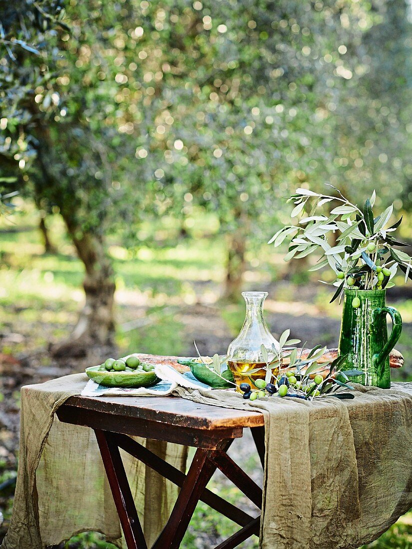 Tisch im Freien mit Oliven und Olivenöl