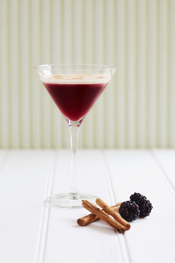 Schwarzer-Johannisbeer-Zimt-Drink in einem Martiniglas