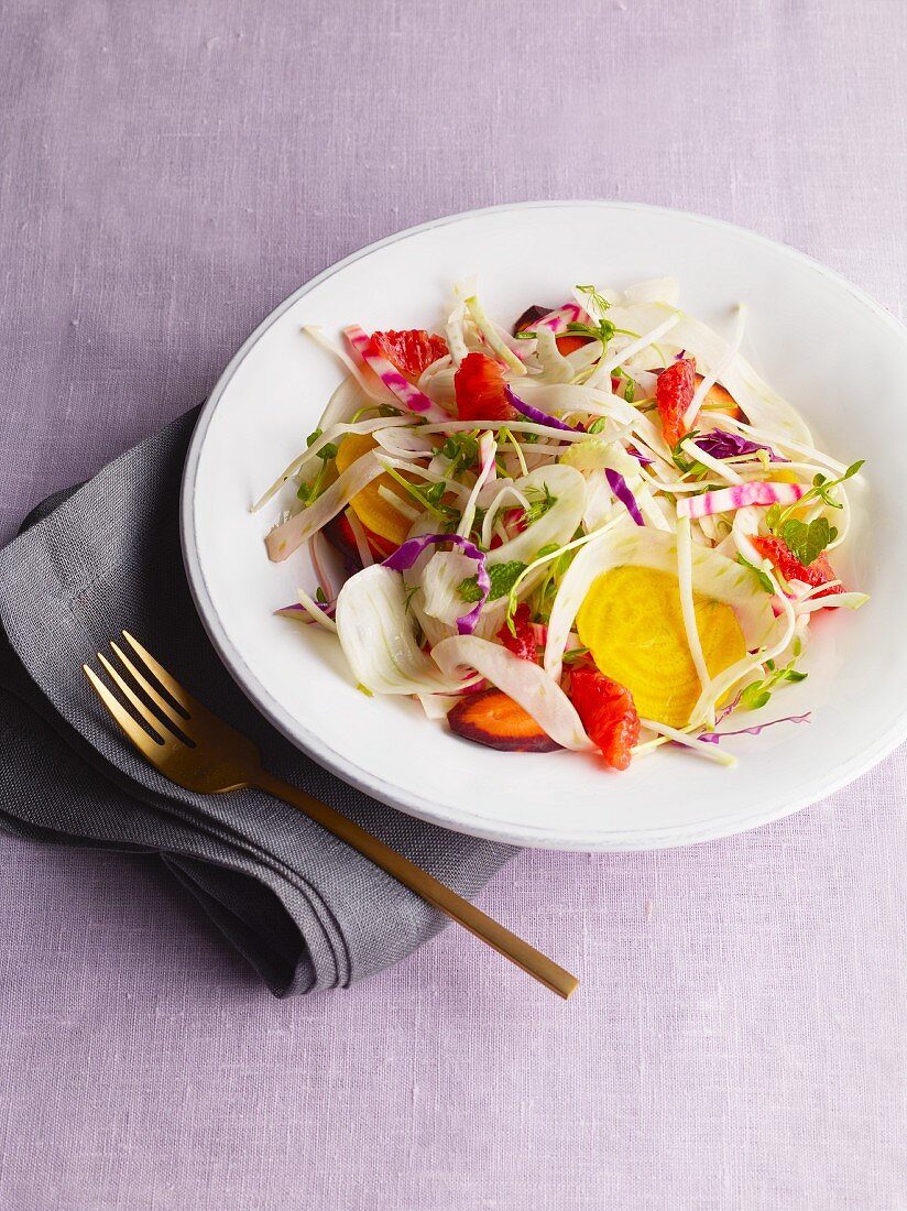 Raw vegetable salad on a plate with a fork