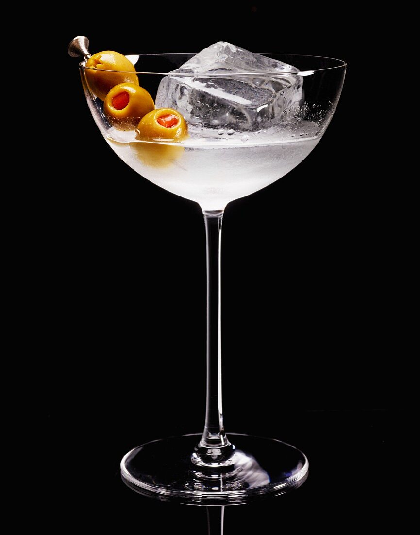 A cocktail with ice cubes and olives