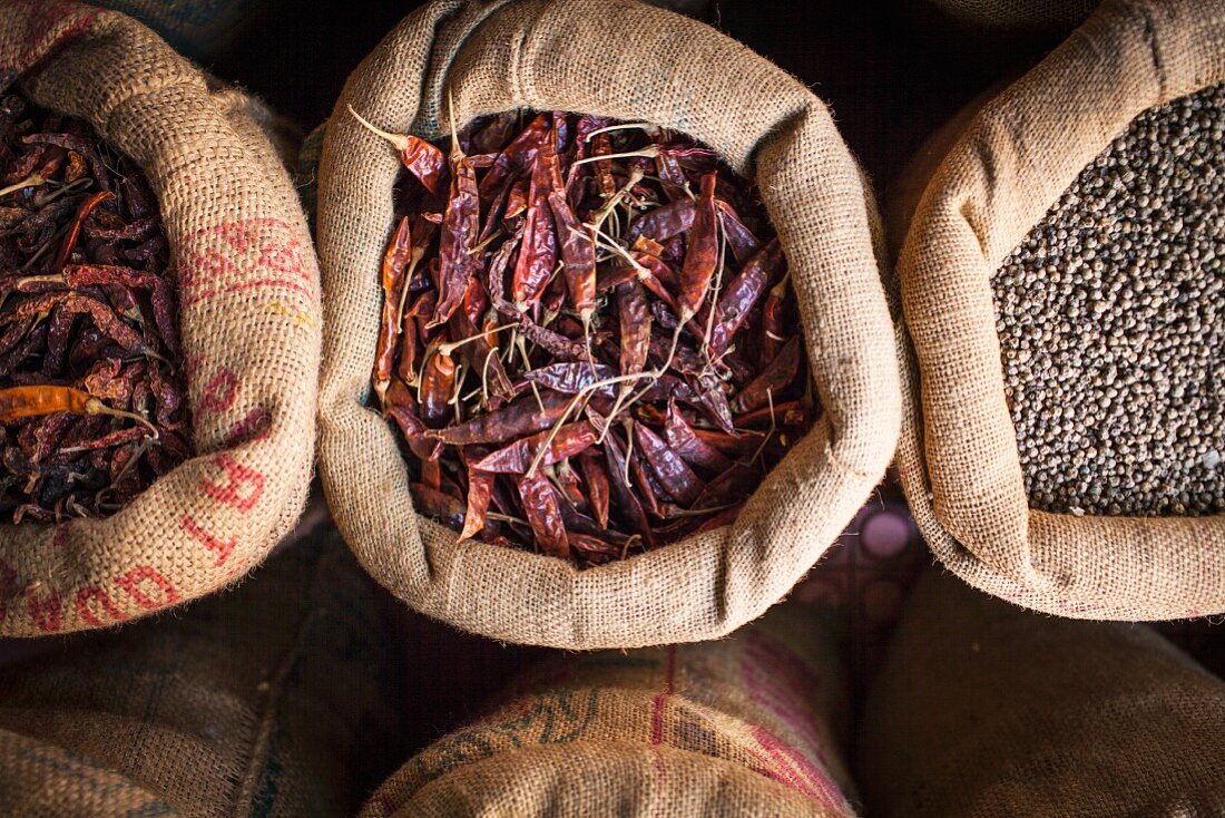 Dried chilli peppers and chickpeas in jute sacks at an Indian street market