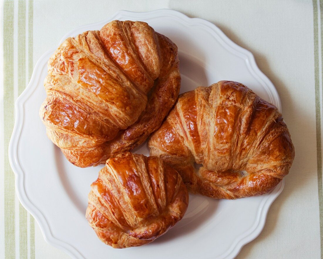 Three croissants on a plate (seen from above)