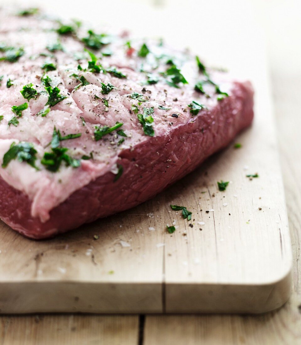 A raw piece of lamb with herbs