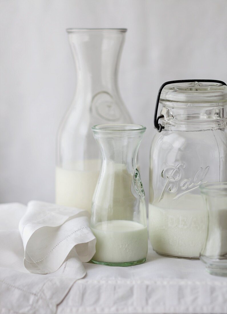 Veganer Milchersatz in verschiedenen Flaschen auf weißem Tischtuch