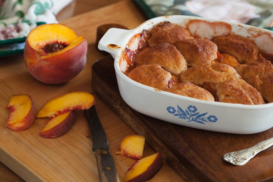 Peach slices and peach cobbler in a baking dish
