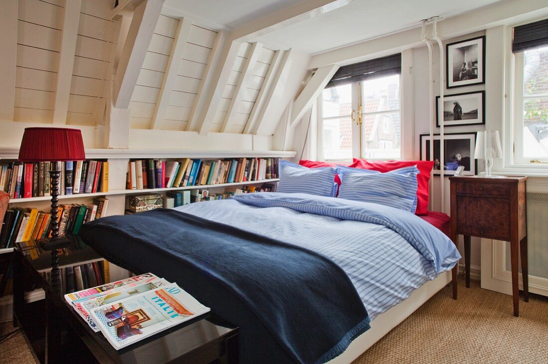 Bookcase built into knee wall of attic room behind double bed