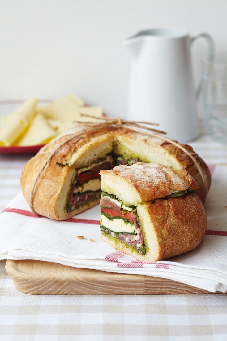 Boule filled with meat, cheese, pesto and peppers