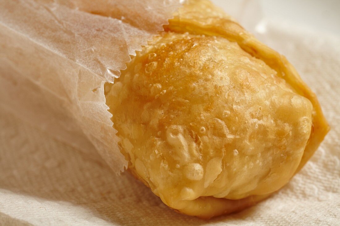 A spring roll in a paper bag (close up)