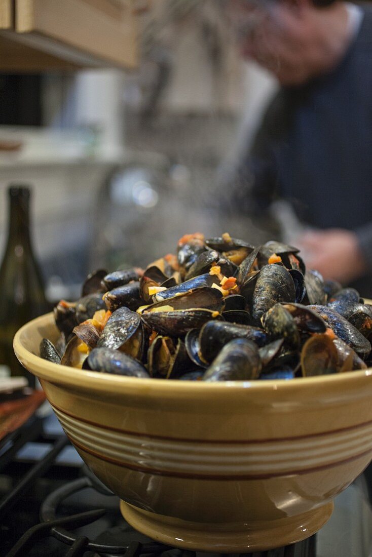 Steamed mussels in a ceramic bowl on a stove