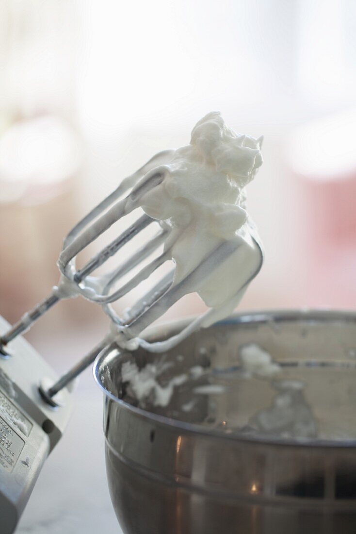 Geschlagener Eischnee auf Rührbesen von Mixer