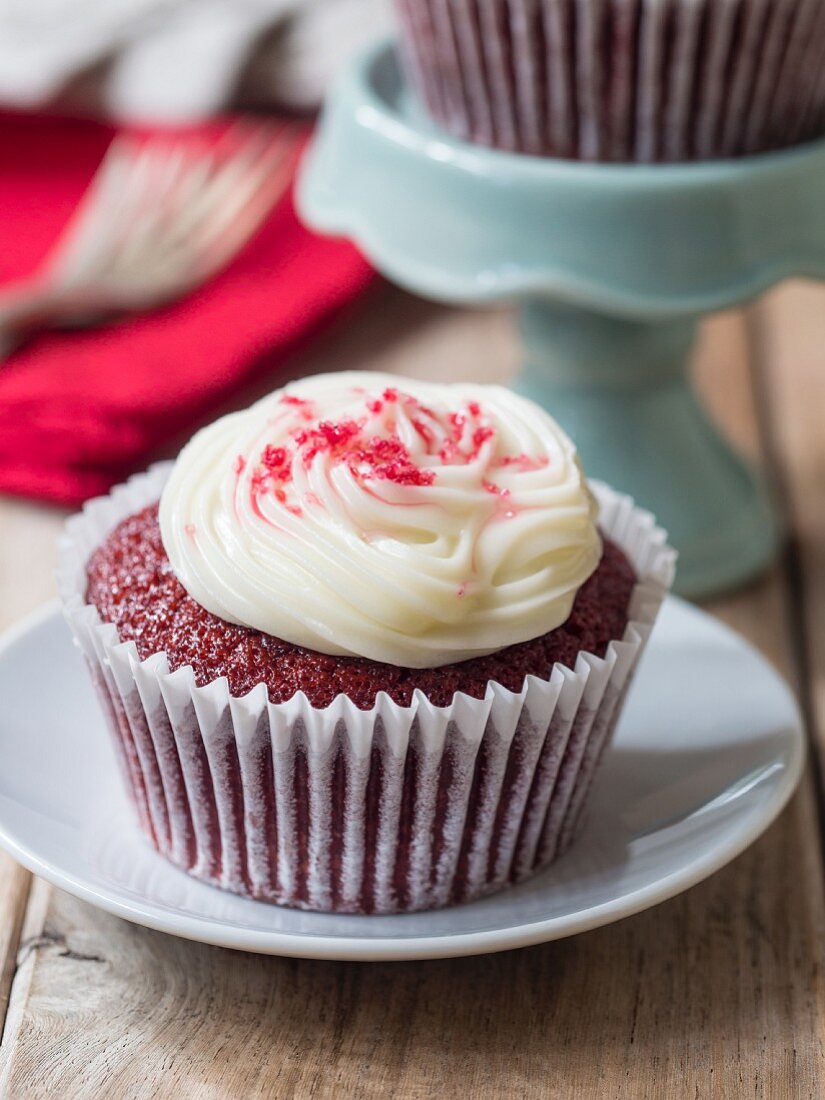 A Red Velvet cupcake with white frosting