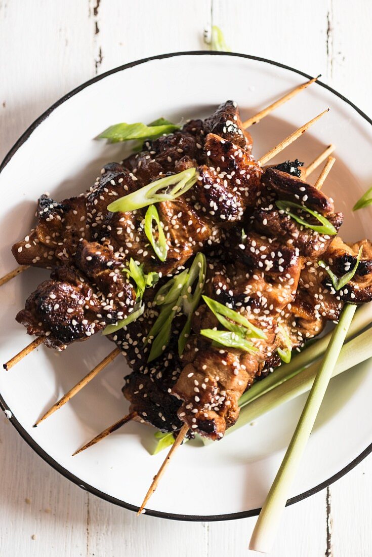 Pork belly skewers with sesame seeds and spring onions