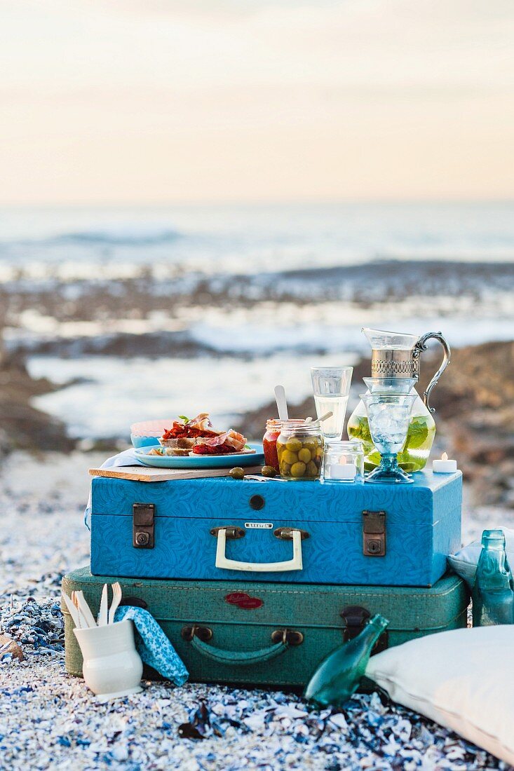 Picknick auf Koffer am Strand