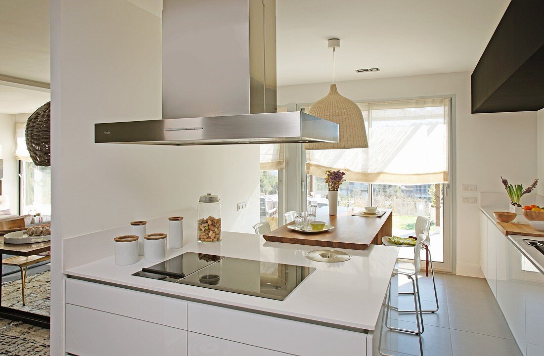 weiße Küchenblock mit Dunstabzugshaube in offener Küche, im Hintergrund Essbereich