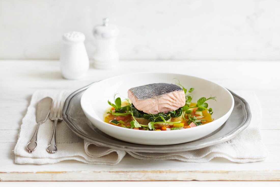 Poached salmon fillet on a bed of vegetables