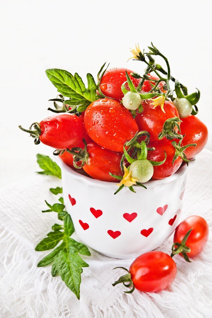 Cherry tomatoes in a vase decorated with red hearts