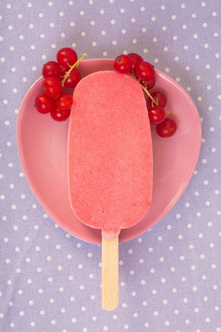 A homemade ice cream stick with redcurrants (seen from above)