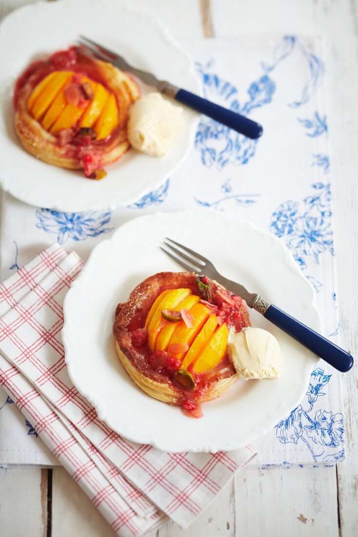 Peach puff pastry tart with raspberry sauce and ice cream