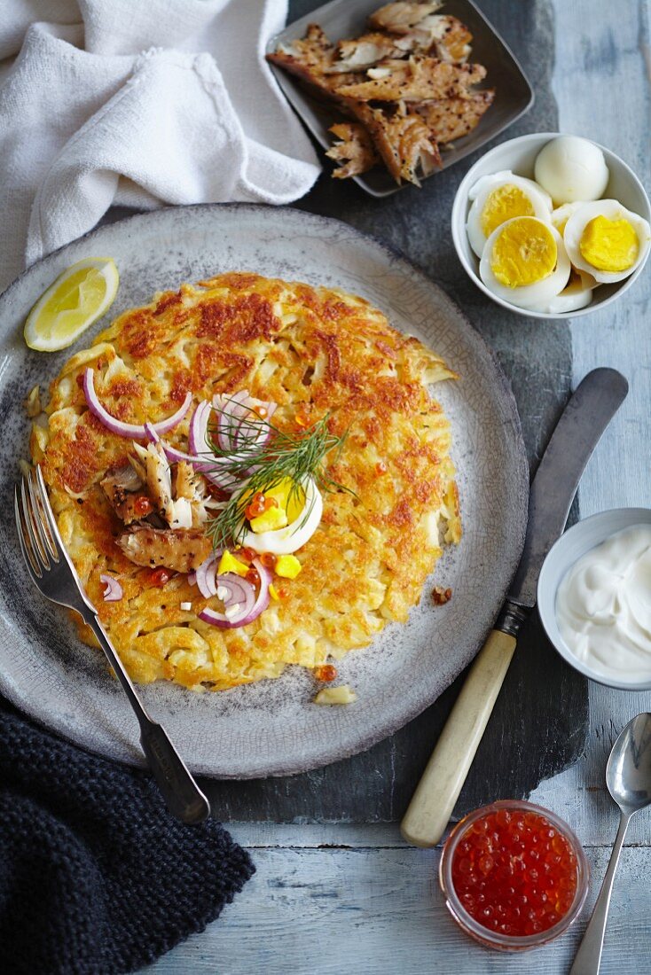 Potato cake with hard-boiled eggs, onions and caviar