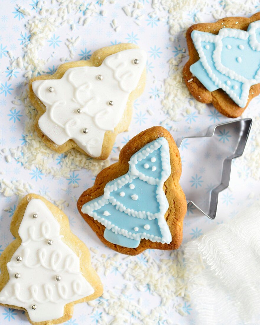 Christmas tree-shaped gingerbread and shortbread biscuits with blue and white icing