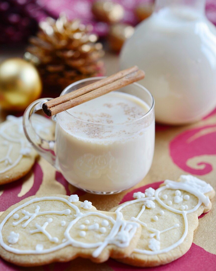 Traditioneller Eierpunsch mit Zimtstangen und Schneemann-Plätzchen (weihnachtlich)