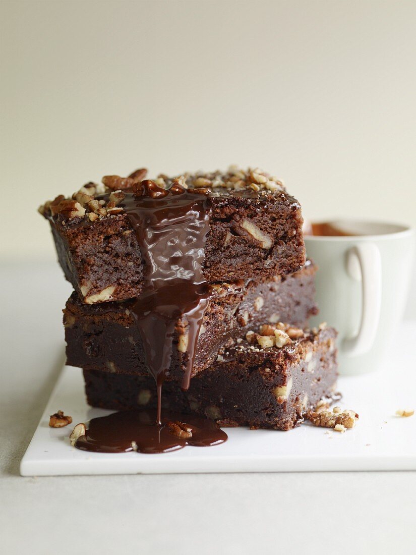 Gestapelte Brownies mit tropfender Schokoladensauce