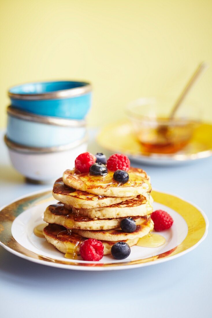 Pancakes topped with blueberries, raspberries and maple syrup (USA)