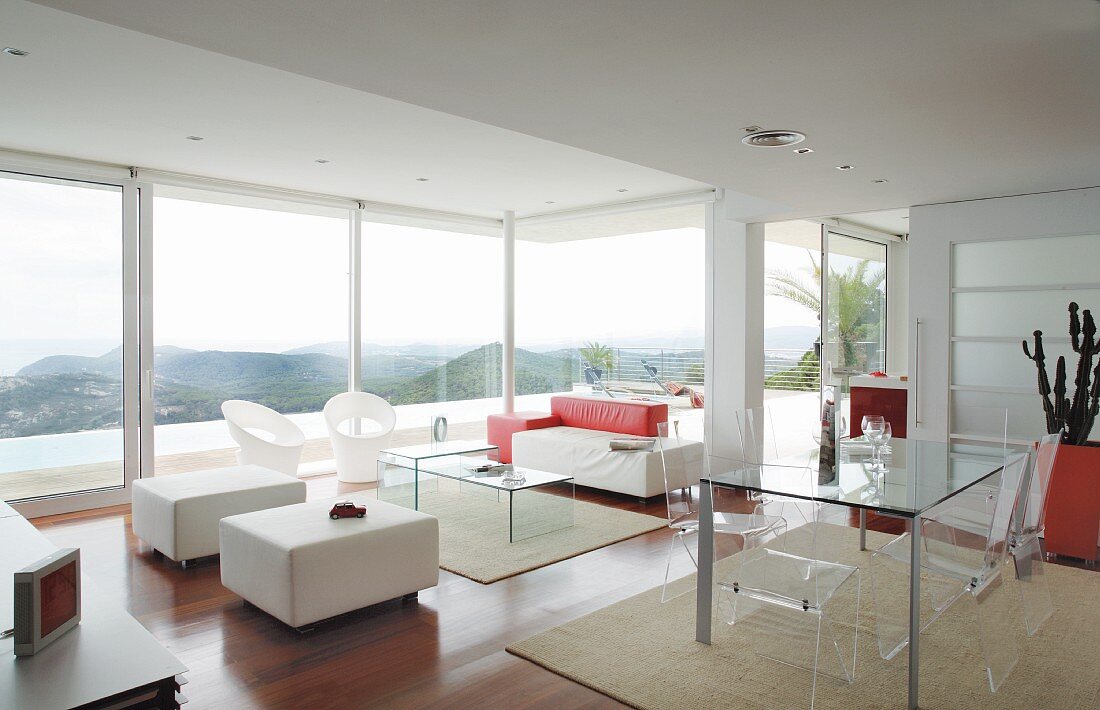Designer-Wohnraum mit Möbeln aus Acrylglas und Landschaftsblick durch Glasfront