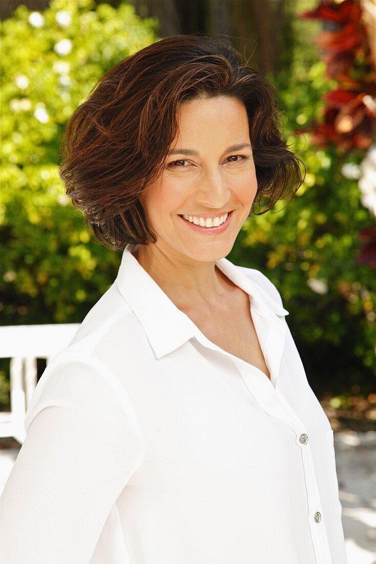 A brunette woman wearing a white blouse