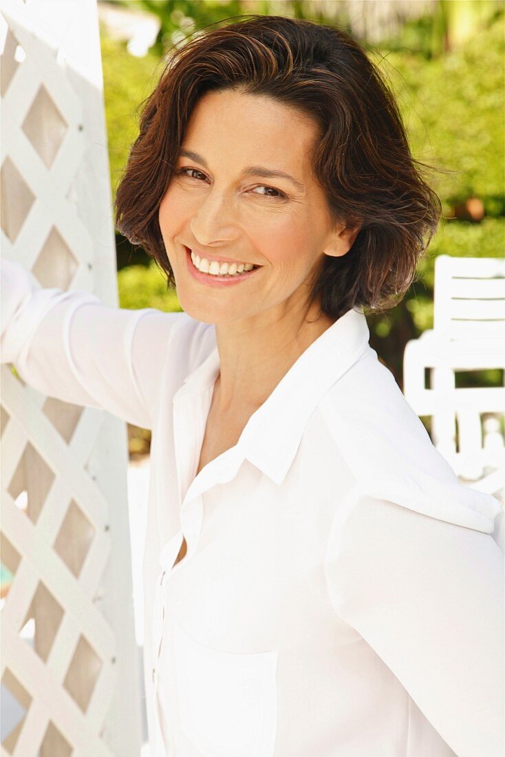 A brunette woman wearing a white blouse