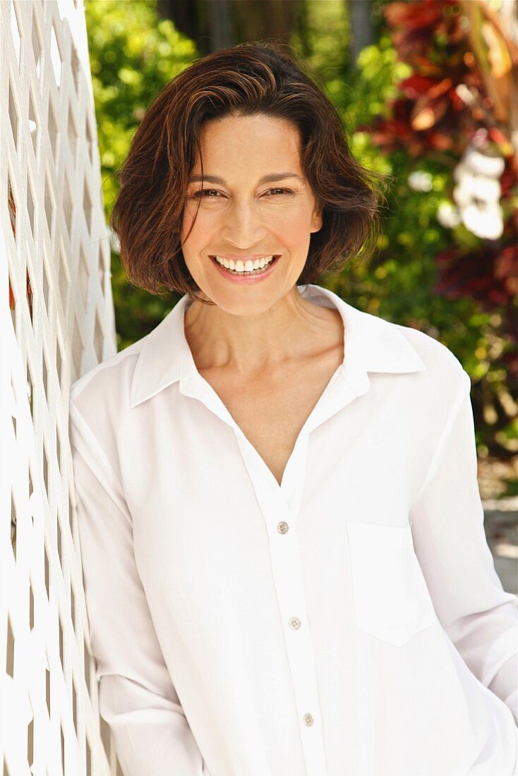 A brunette woman wearing a white blouse